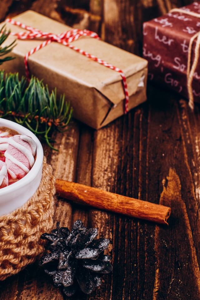 Чашка какао с маршмеллоу на столе с подарками