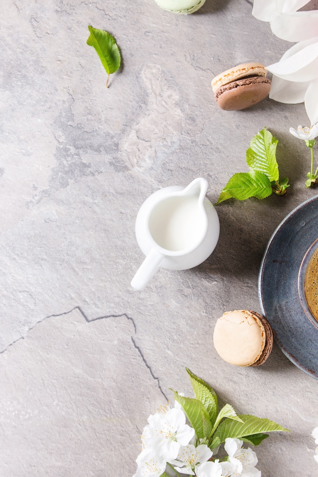 Чашка кофе на сером фоне с цветами вишни и магнолии