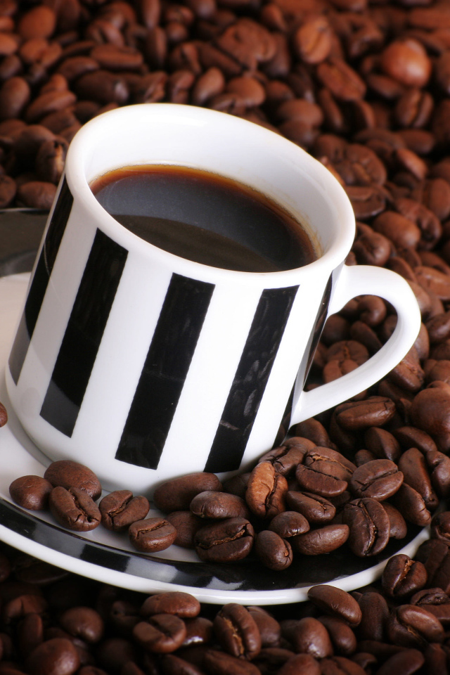 Чашка кофе на столе с кофейными зернами