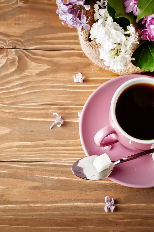 Чашка кофе на деревянном столе с сиренью 