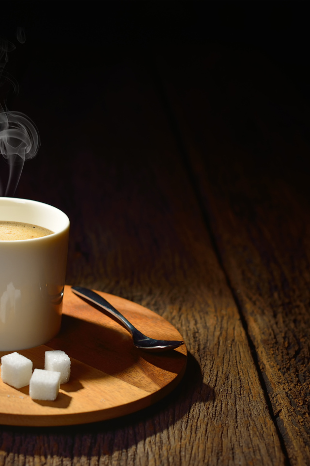 Чашка горячего кофе на столе с сахаром