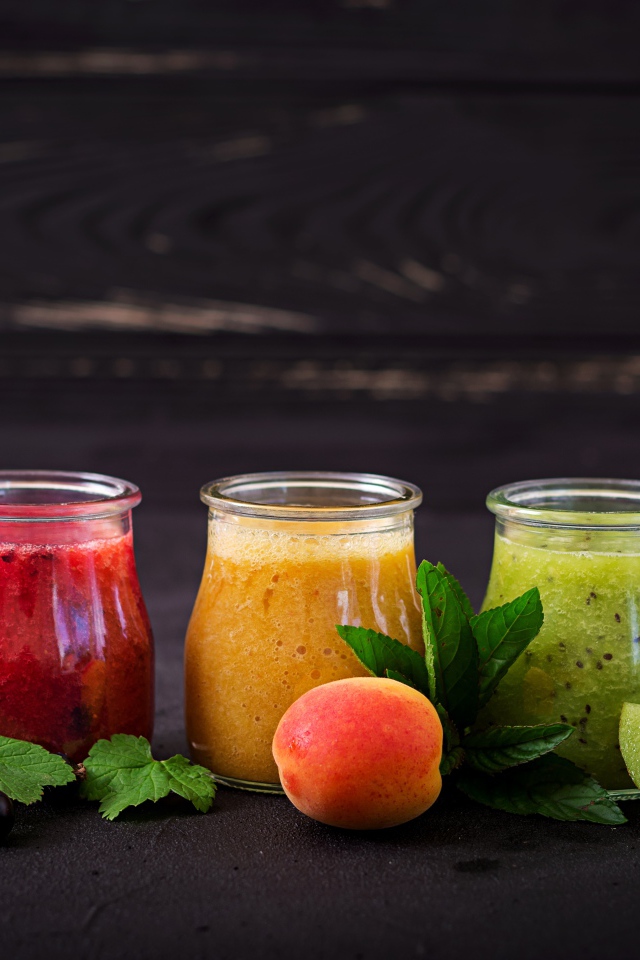 Фруктовое смузи в баночках на столе 