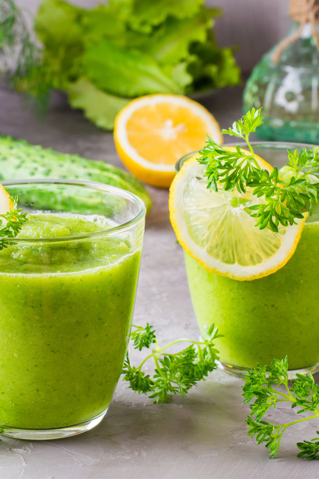 Зеленый смузи в стаканах с кусочками лимона и петрушкой
