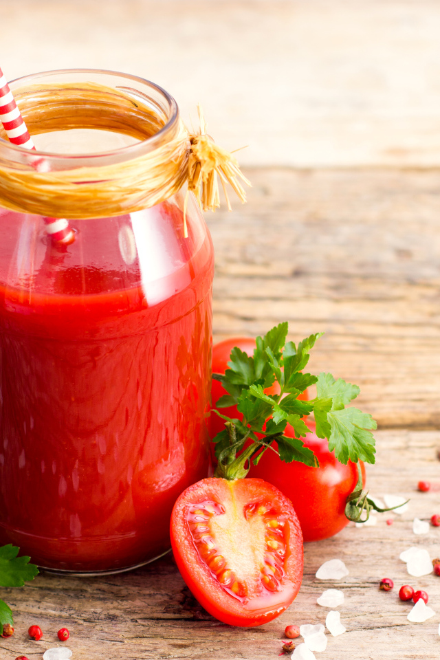 Банка томатного сока на столе с помидорами и петрушкой