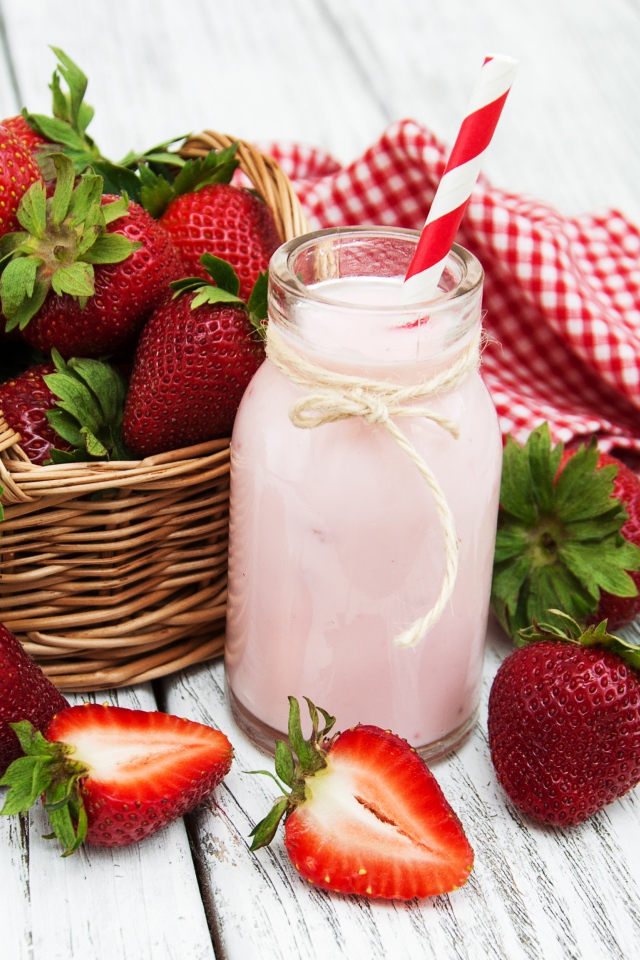 Банка с коктейлем на столе с ягодами клубники