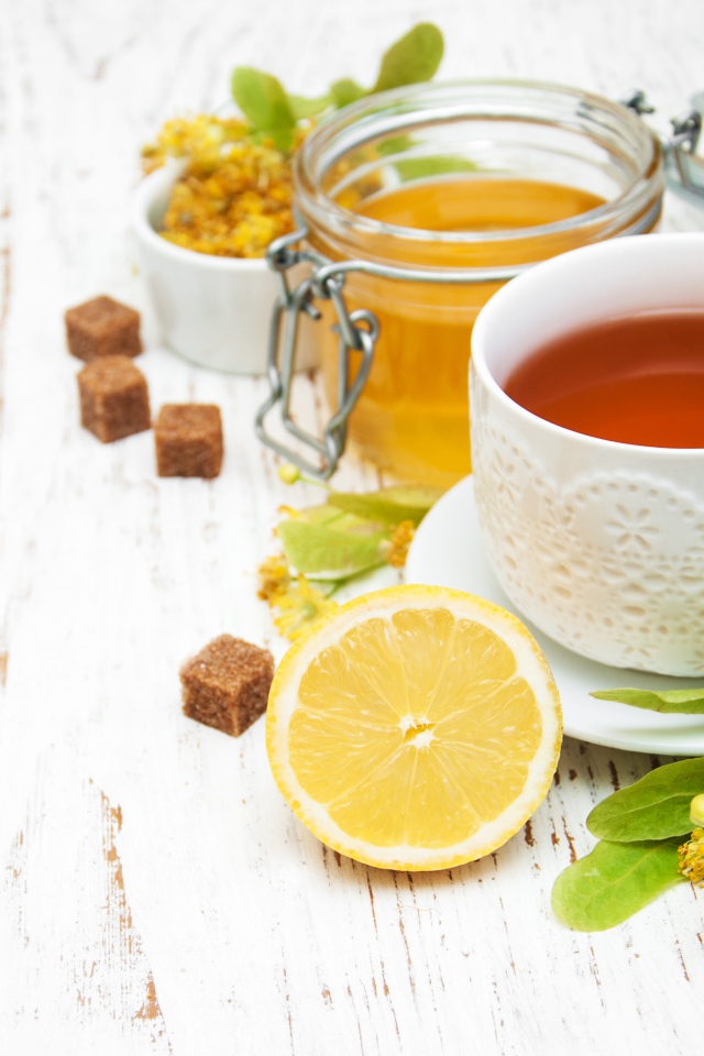 Липовый чай на столе с медом, лимоном, и сахаром