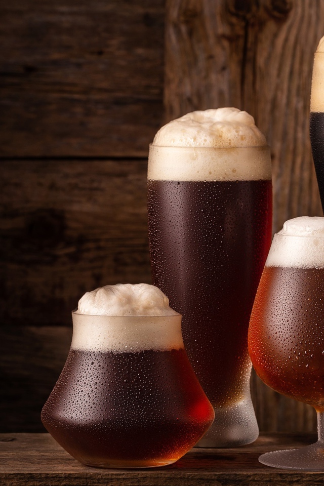 Много бокалов холодного пенного пива на столе 