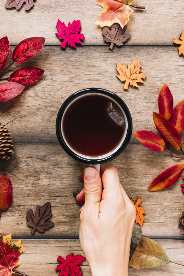 Кружка чая на столе с осенними листьями