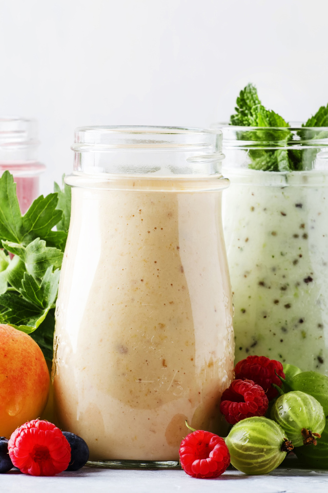 Банки со смузи на столе с ягодами 