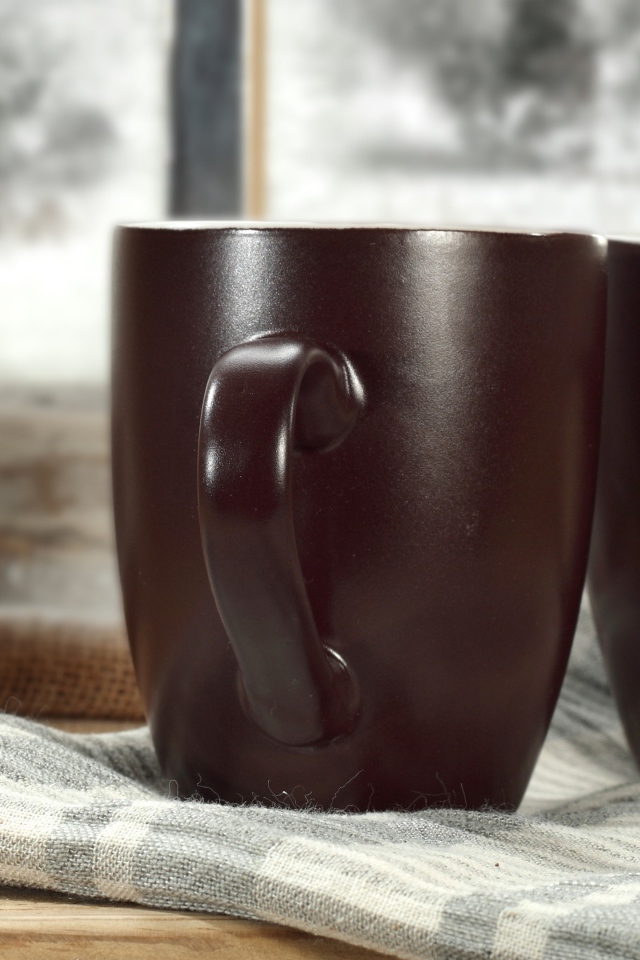 Две коричневые чашки кофе на столе с шарфом