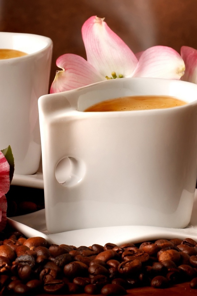 Две чашки кофе на столе с кофейными зернами и цветами