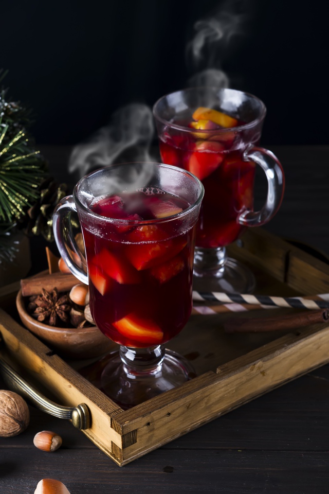 Два стакана горячего глинтвейна на столе с еловой веткой