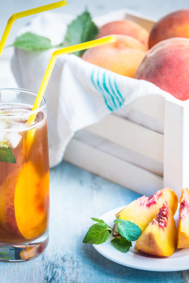 Два стакана сока на столе с персиками