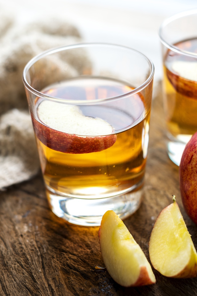 Два стакана сока на столе с яблоками 