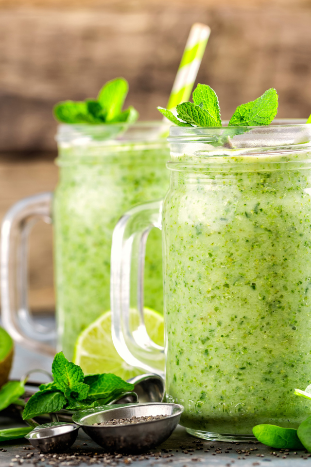 Два зеленых смузи на столе с киви, мятой и зеленым яблоком