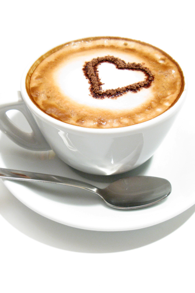 Белая чашка с капучино с сердцем из корицы на пене 
