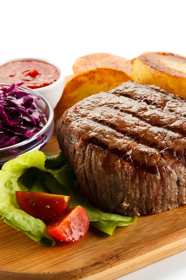 Кусок мяса гриль на доске с салатом и овощами