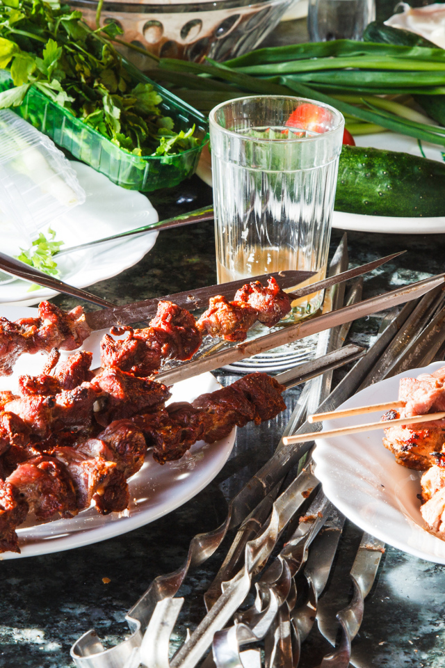 Аппетитный шашлык на шампурах на столе 