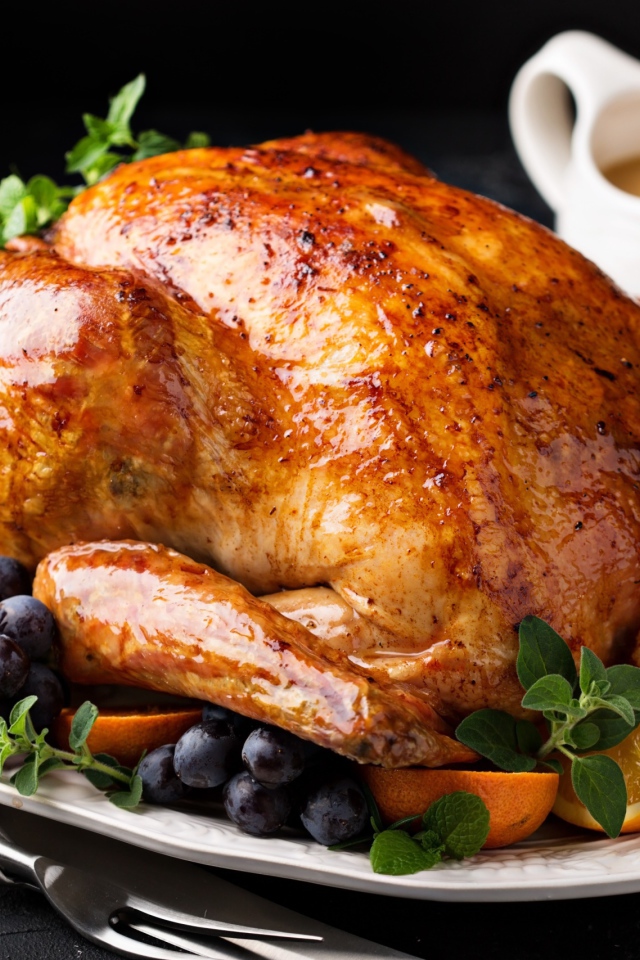 Запеченная курица на тарелке апельсинами и ягодами 