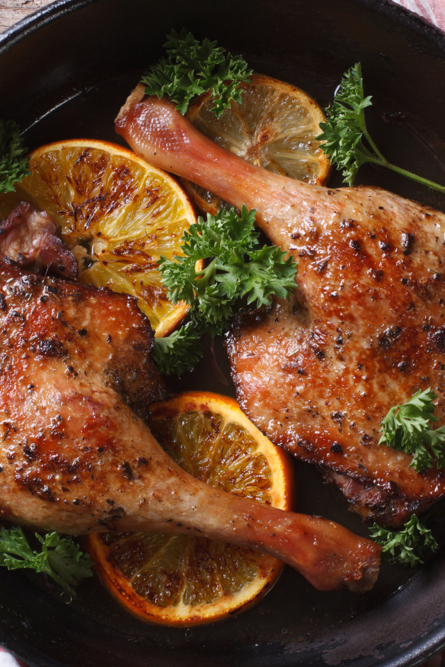 Куриные окорочка в сковороде с кольцами апельсина и петрушкой
