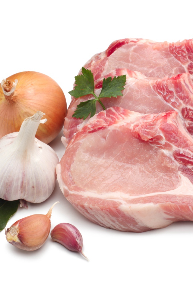 Куски мяса на белом фоне с луком и чесноком