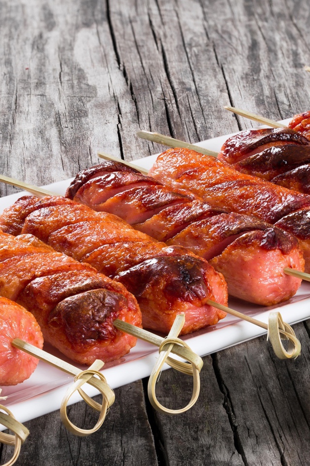 Сосиски гриль на шпажках на столе с соусом