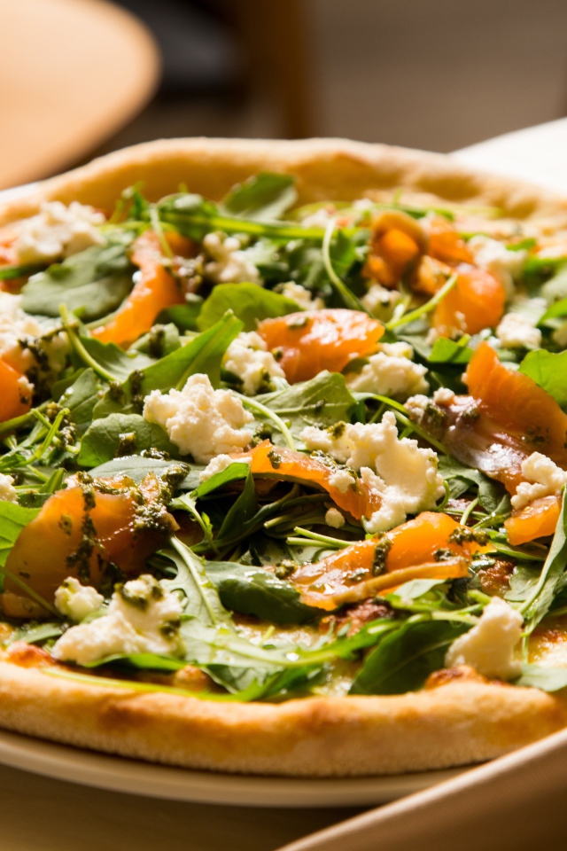 Аппетитная пицца с рыбой и зеленью на столе