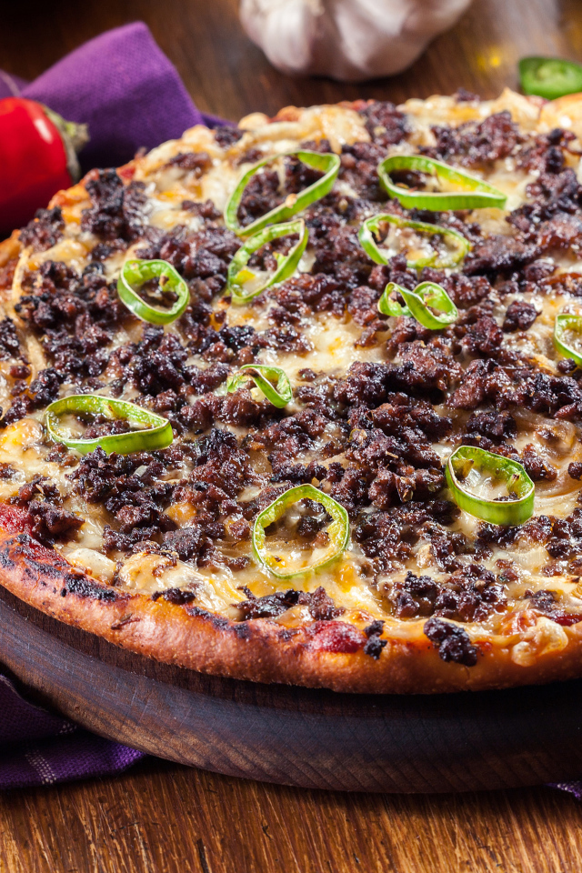 Пицца на доске с мясом и перцем 