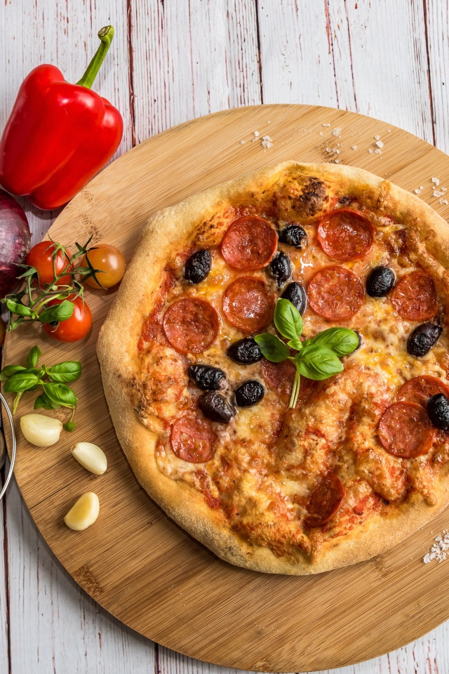 Пицца на доске с овощами и солью 