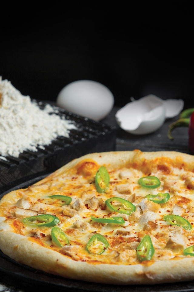 Пицца на столе с яйцами и перцем