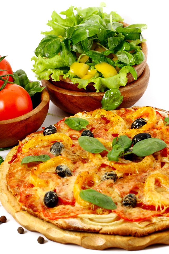 Пицца на столе с овощами и зеленью на белом фоне