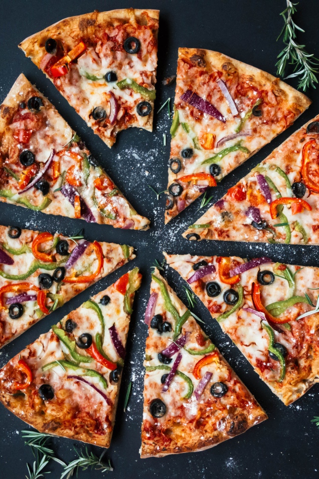 Пицца нарезанна на куски на сером столе