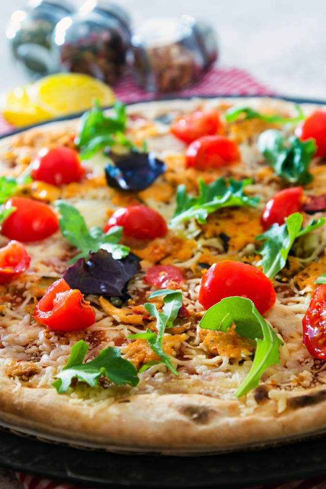 Пицца с помидорами, рукколой и сыром на столе