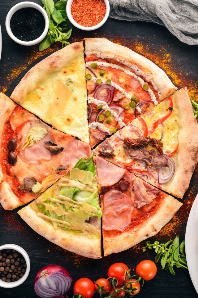 Пицца с различными начинками  на столе со специями