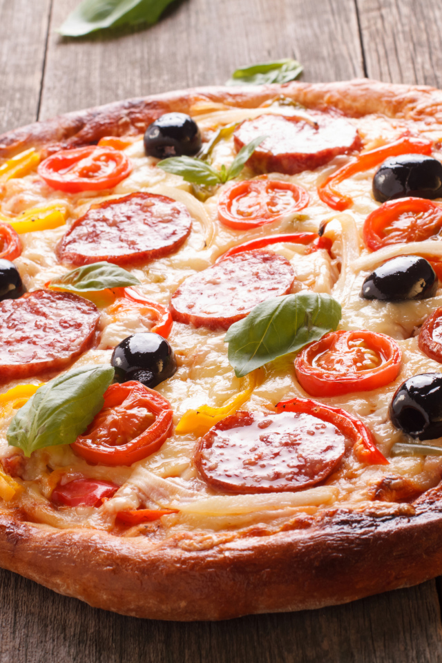 Румяная пицца с колбасой, помидорами, оливками и сыром