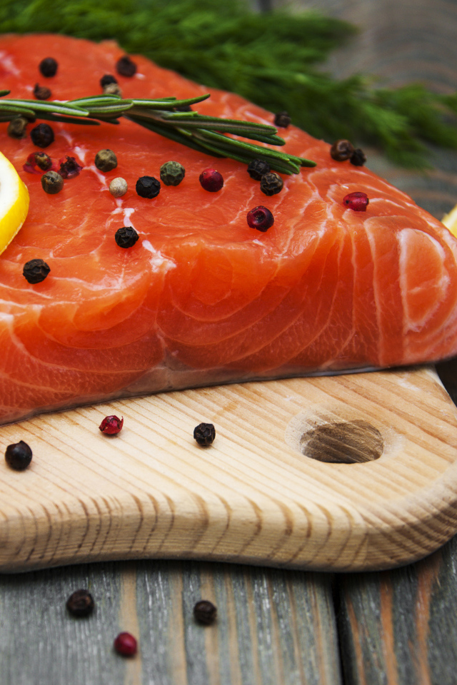 Кусок красной рыбы с лимоном и черным перцем