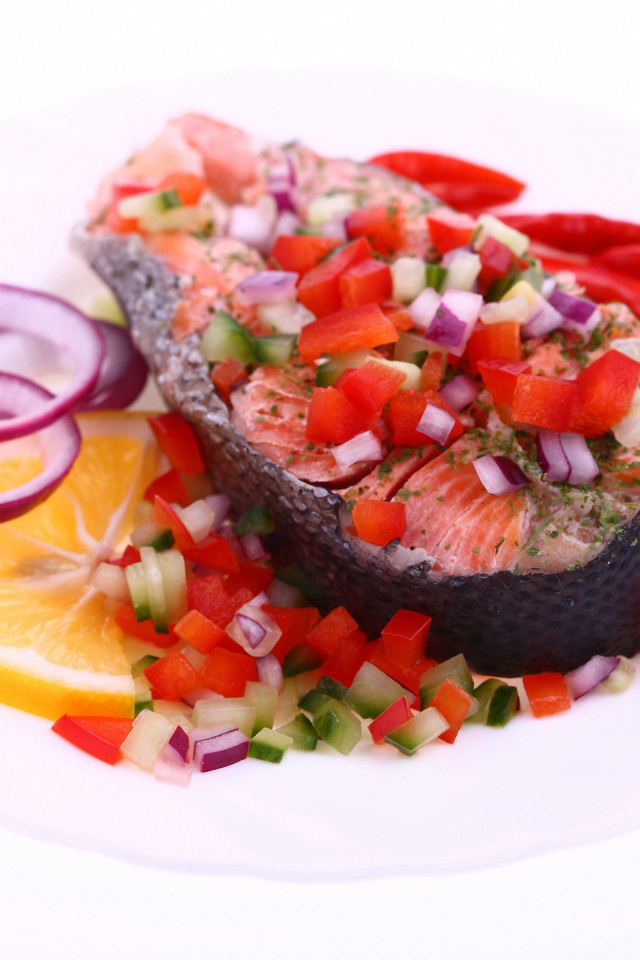 Кусок красной рыбы с овощами на белом фоне