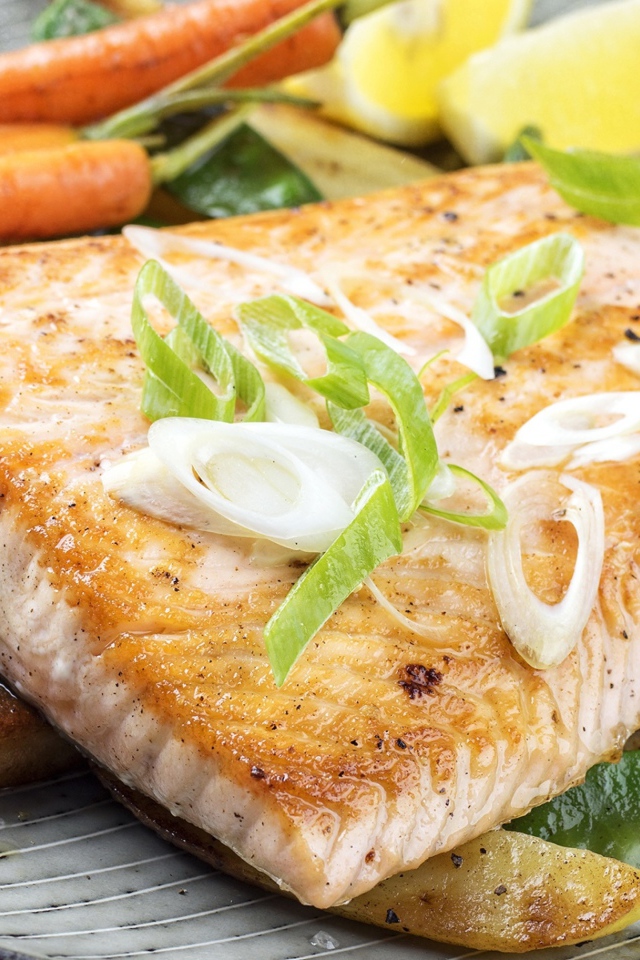 Запеченная красная рыба с овощами на тарелке