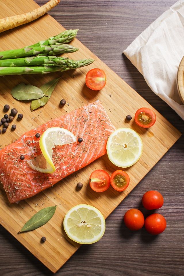 Красная рыба на столе со специями и овощами