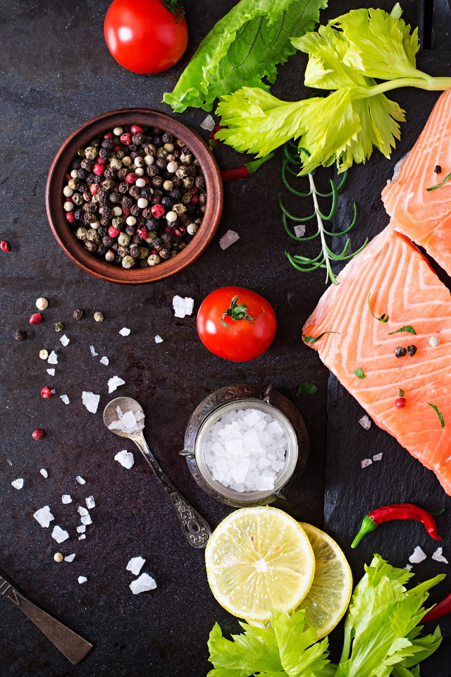 Куски красной рыбы на столе с лимоном и специями