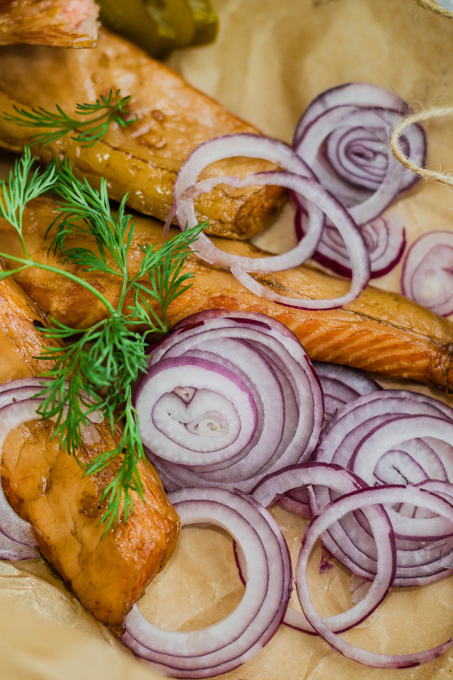 Копченое филе рыбы на бумаге с луком