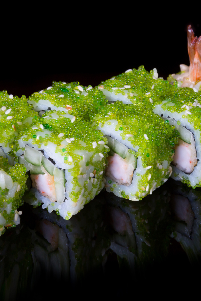 Суши с икрой и креветками на черном фоне