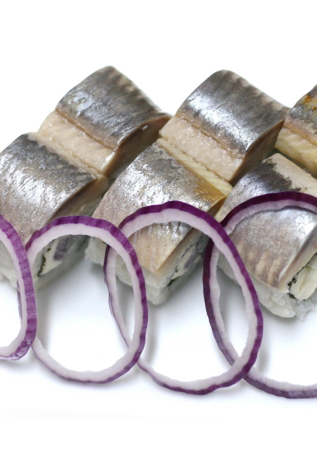 Суши с кусочками сельди на белом фоне с кольцами лука