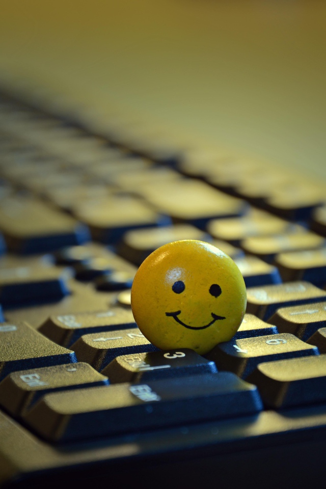 Yellow smiley face on black keyboard