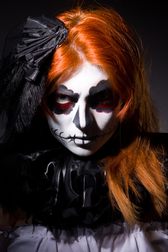 Рыжеволосая девушка с маской на лице на Хэллоуин 