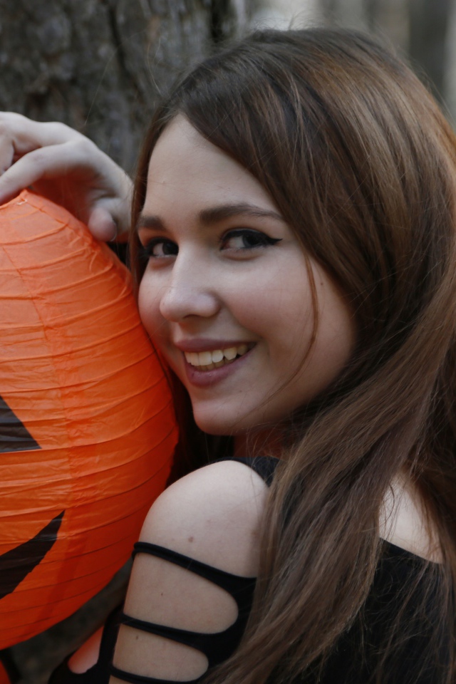 Улыбающаяся девушка с декором на праздник Хэллоуин