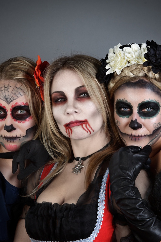 Три девушки с масками и в костюмах на Хэллоуин 
