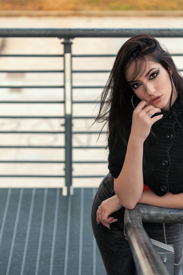 Красивая девушка стоит на ступеньках у перил 