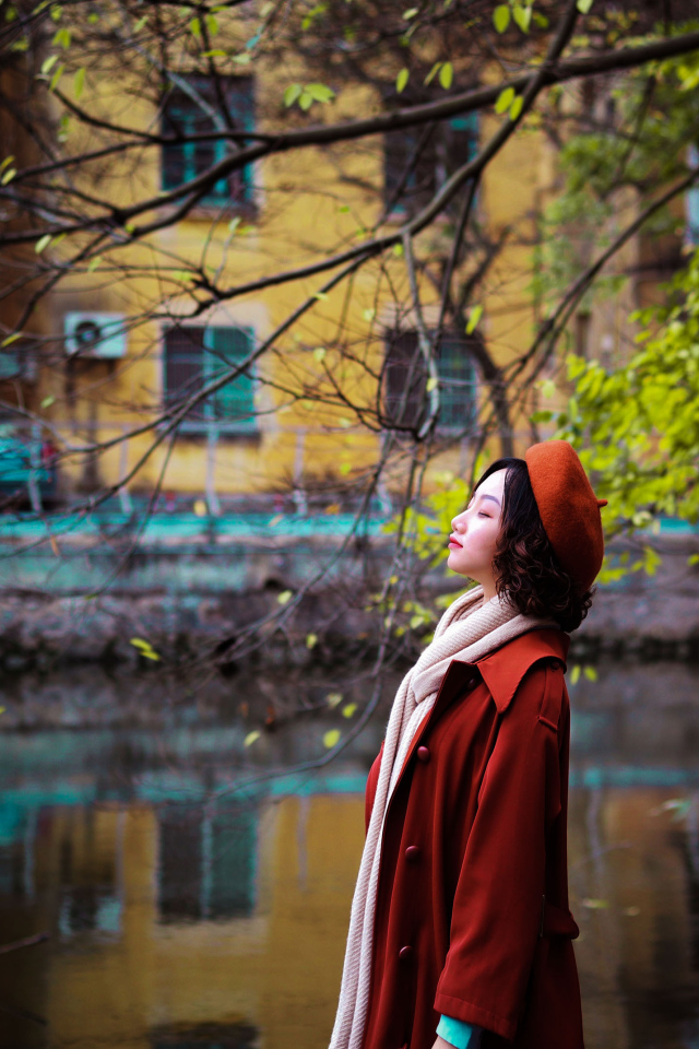 Девушка азиатка в красном пальто у воды