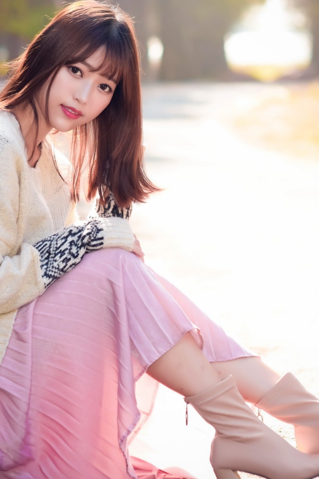 Девушка азиатка сидит на земле 